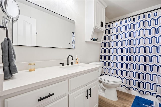 bathroom featuring hardwood / wood-style floors, vanity, a shower with shower curtain, and toilet