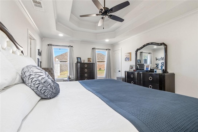 bedroom with a raised ceiling, ceiling fan, and ornamental molding