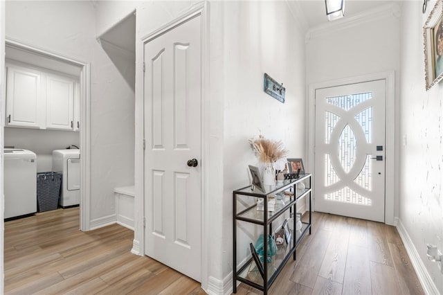 entrance foyer featuring washing machine and dryer, light hardwood / wood-style floors, and crown molding