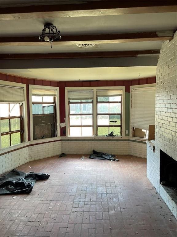 unfurnished sunroom featuring a fireplace