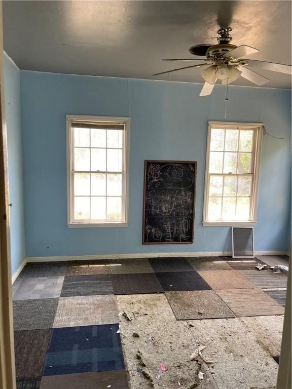 unfurnished room with ceiling fan and a wealth of natural light