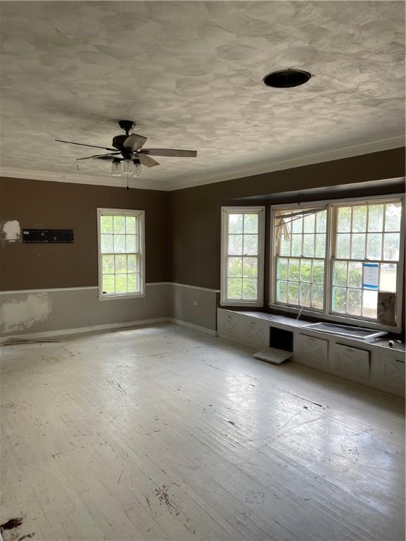 spare room with plenty of natural light, ceiling fan, crown molding, and light hardwood / wood-style flooring