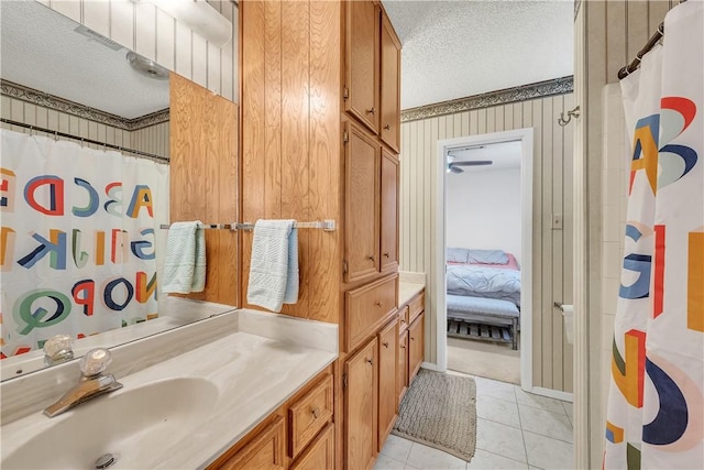 bathroom with vanity, a shower with curtain, a textured ceiling, and tile patterned floors