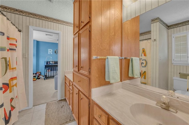 bathroom featuring tile patterned flooring, vanity, a textured ceiling, and toilet