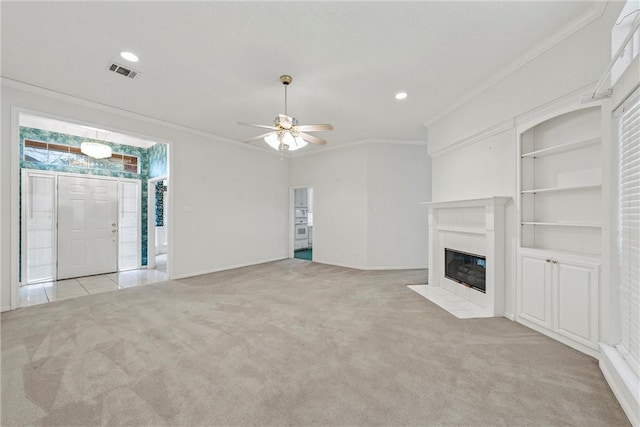 unfurnished living room featuring crown molding, light colored carpet, built in features, and ceiling fan