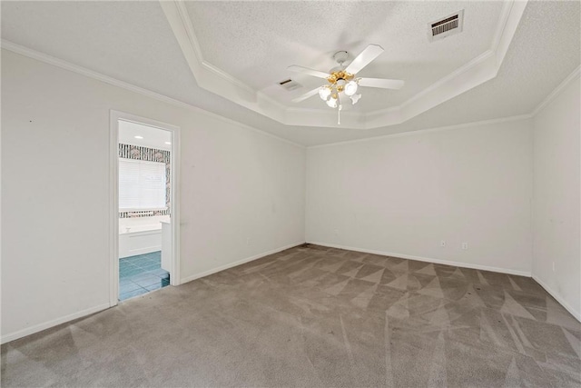 carpeted spare room with ornamental molding, a raised ceiling, and ceiling fan