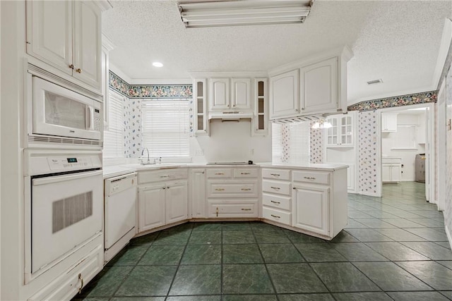 kitchen with sink, a textured ceiling, white cabinets, and white appliances