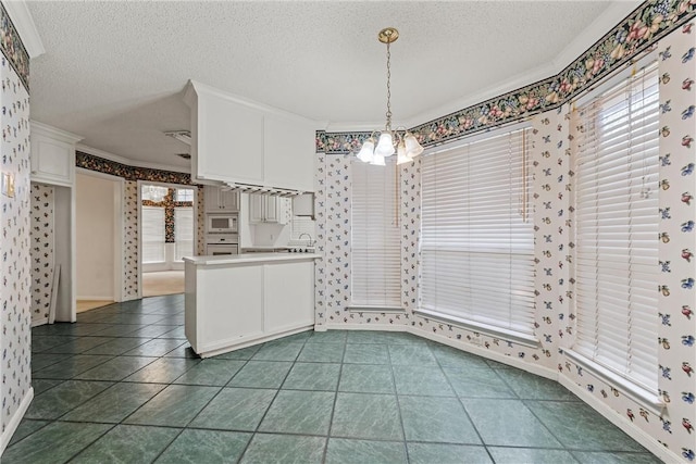 kitchen featuring a textured ceiling, ornamental molding, pendant lighting, white appliances, and white cabinets