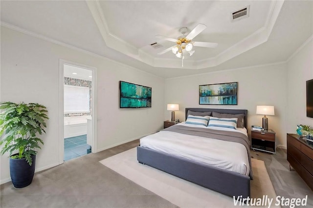 carpeted bedroom with crown molding, ceiling fan, connected bathroom, and a raised ceiling