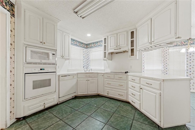 kitchen featuring white cabinetry, white appliances, plenty of natural light, and a textured ceiling