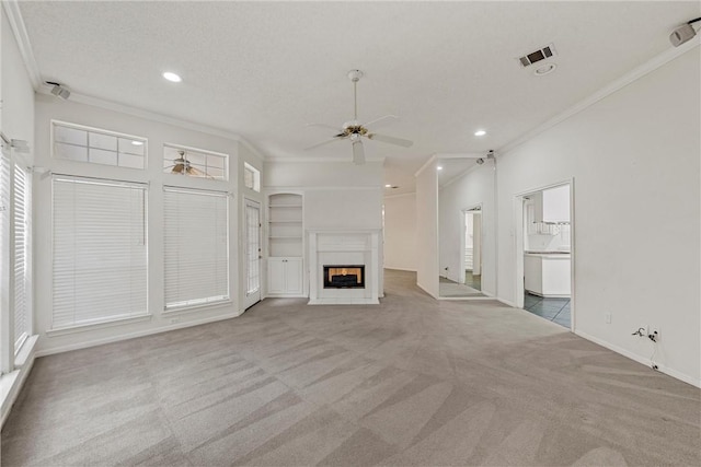 unfurnished living room with built in features, carpet floors, ornamental molding, and ceiling fan