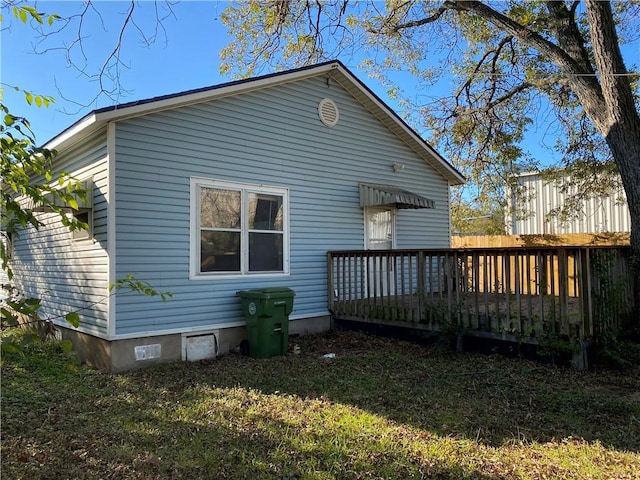 back of house with a lawn and a deck