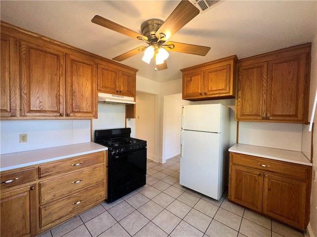 kitchen featuring gas stove, ceiling fan, light tile patterned flooring, and white refrigerator