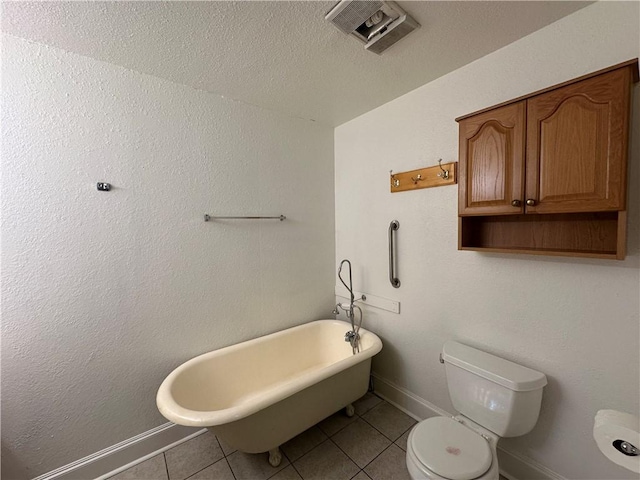 bathroom with a tub to relax in, tile patterned flooring, and toilet