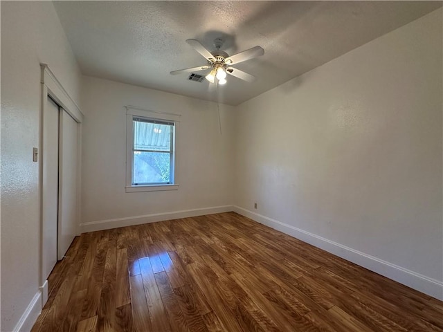 unfurnished bedroom featuring hardwood / wood-style flooring, ceiling fan, a textured ceiling, and a closet