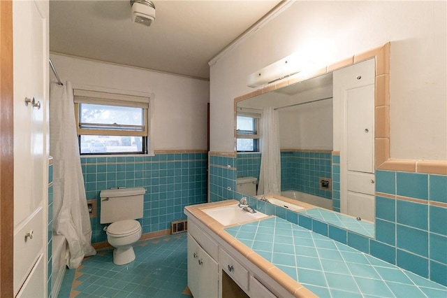 full bathroom with shower / tub combo, vanity, tile patterned floors, and tile walls