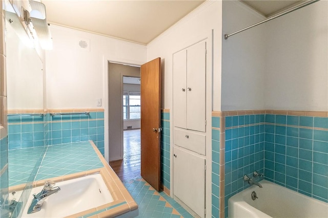 bathroom featuring tile patterned floors, vanity, tile walls, and shower / tub combination