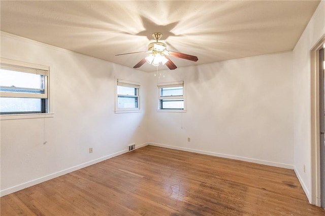 empty room with hardwood / wood-style floors, plenty of natural light, and ceiling fan