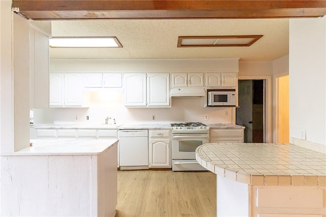 kitchen featuring white cabinetry, white appliances, kitchen peninsula, and light wood-type flooring