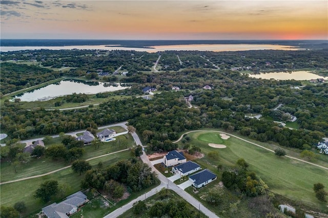 aerial view at dusk featuring a water view