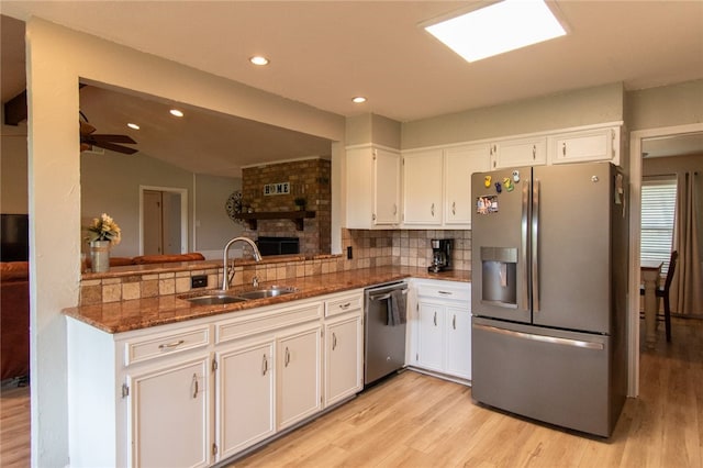 kitchen with sink, white cabinetry, stainless steel appliances, and light wood-type flooring