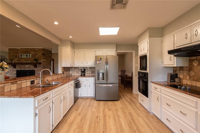 kitchen with backsplash, sink, black appliances, light hardwood / wood-style floors, and white cabinetry