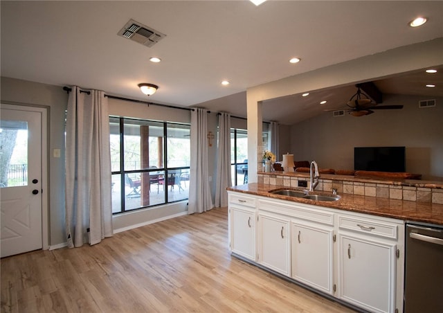 kitchen featuring sink, stainless steel dishwasher, vaulted ceiling with beams, light hardwood / wood-style floors, and white cabinetry