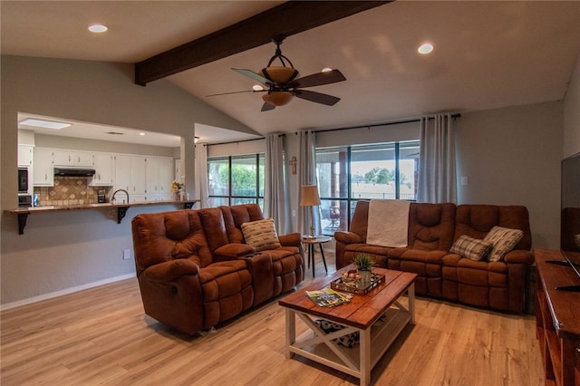 living room with vaulted ceiling with beams, light hardwood / wood-style floors, and ceiling fan