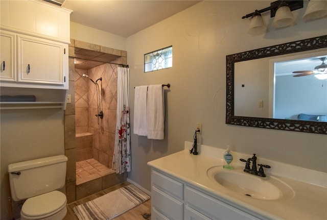 bathroom with ceiling fan, a shower with curtain, hardwood / wood-style floors, toilet, and vanity