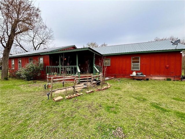 view of front of house featuring metal roof, board and batten siding, and a front yard