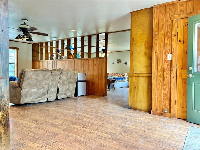 living area with a ceiling fan and wood finished floors