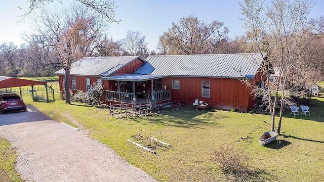 view of front of home with driveway, metal roof, and a front lawn