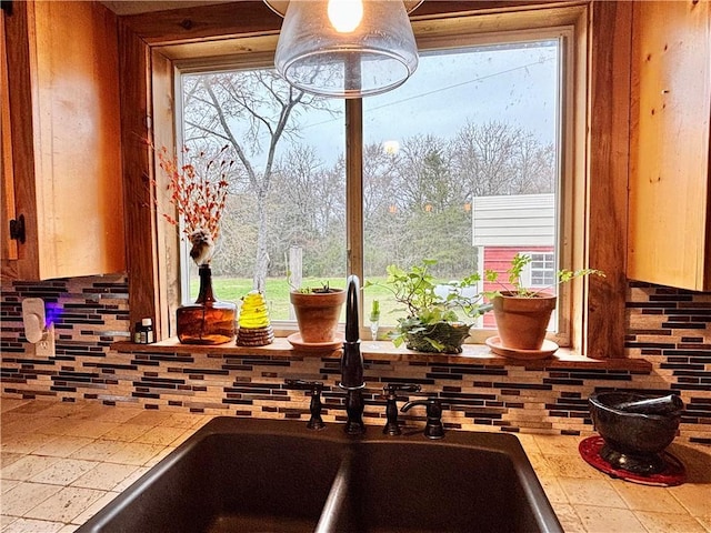 interior details with tile countertops, a sink, and backsplash