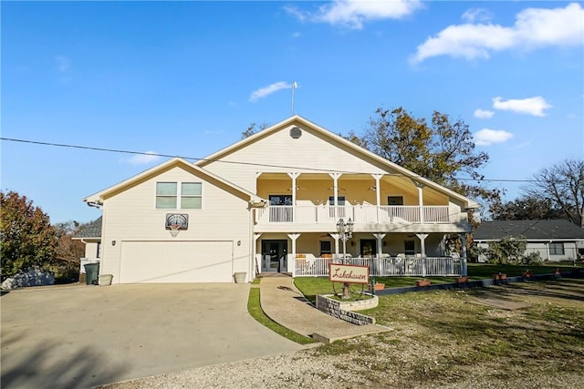 view of front of property with a front lawn, covered porch, and a garage