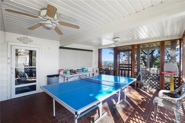 recreation room featuring beam ceiling and ceiling fan