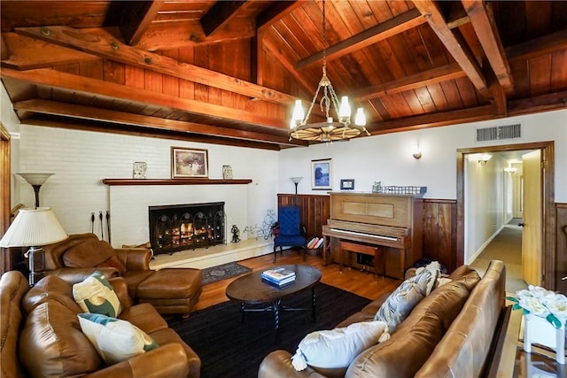 living room with wood walls, vaulted ceiling with beams, a notable chandelier, wood-type flooring, and wood ceiling