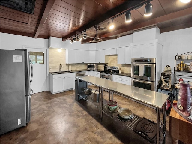 kitchen featuring tasteful backsplash, stainless steel appliances, sink, beamed ceiling, and white cabinetry