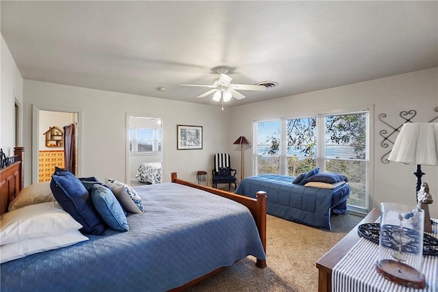 carpeted bedroom featuring multiple windows and ceiling fan