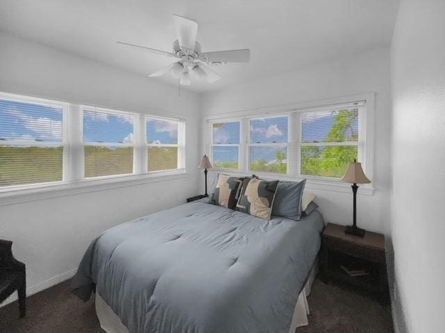 bedroom featuring ceiling fan and dark colored carpet