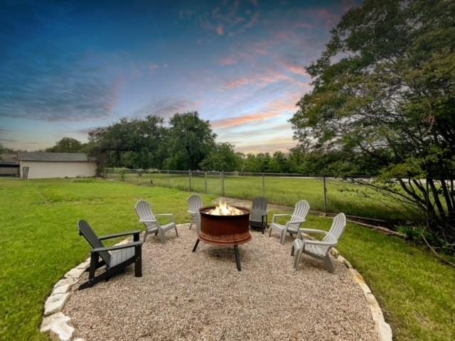 yard at dusk featuring an outdoor fire pit