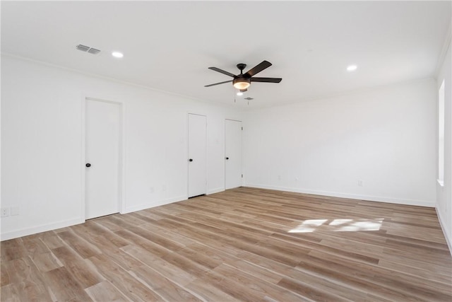 spare room featuring light wood-type flooring, ceiling fan, and ornamental molding