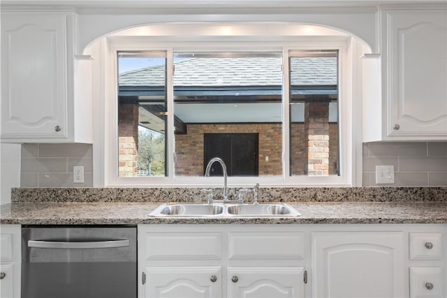 kitchen featuring backsplash, white cabinetry, sink, and stainless steel dishwasher