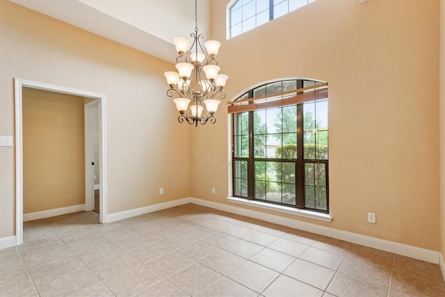 empty room with light tile patterned flooring and a chandelier