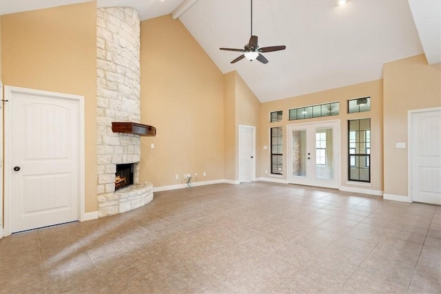 unfurnished living room featuring ceiling fan, light tile patterned floors, a stone fireplace, high vaulted ceiling, and beamed ceiling