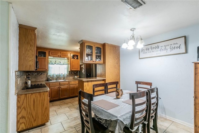 tiled dining room with sink and an inviting chandelier