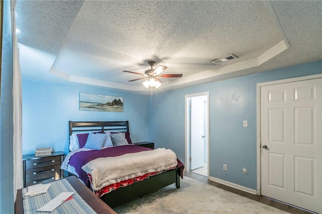 bedroom featuring hardwood / wood-style floors, a raised ceiling, and ceiling fan