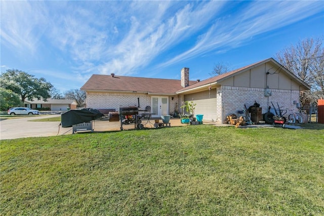 back of house with a patio area, a yard, and a garage