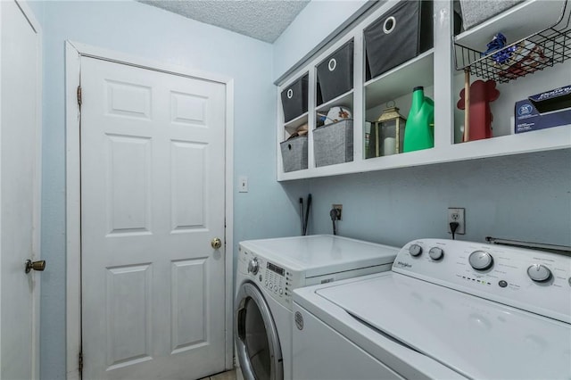 laundry area featuring a textured ceiling and washing machine and clothes dryer