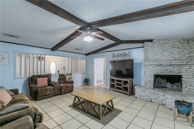 living room featuring a fireplace, a textured ceiling, lofted ceiling with beams, and light tile patterned flooring