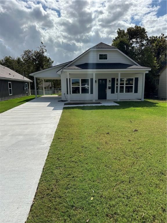 view of front facade with a front lawn and a carport